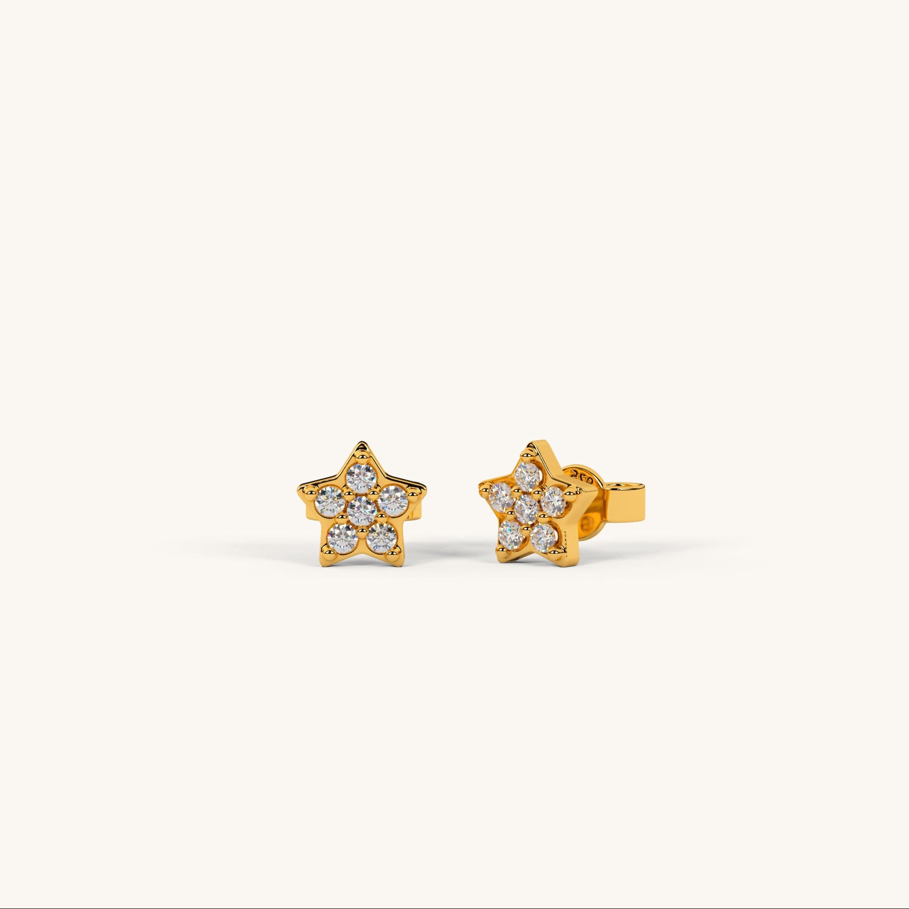 Gold star-shaped earrings with clear stones on a white background