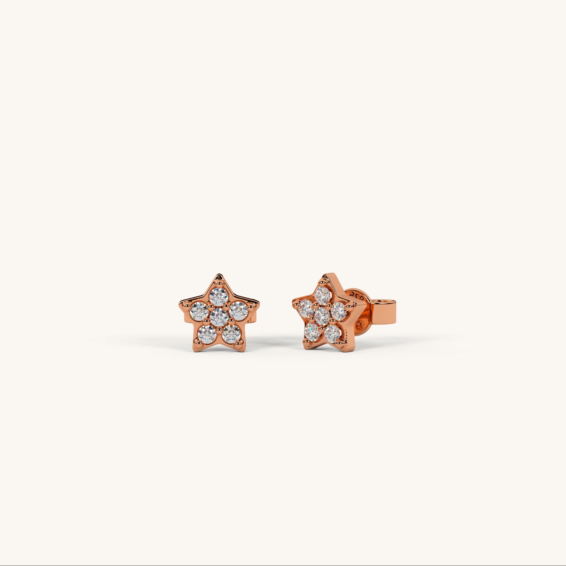 Rose gold star-shaped earrings with clear gemstones on a white background