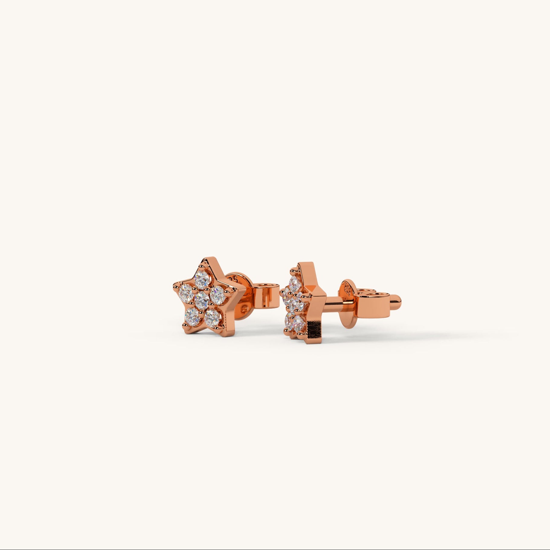 Rose gold star-shaped earrings with clear gemstones on a white background