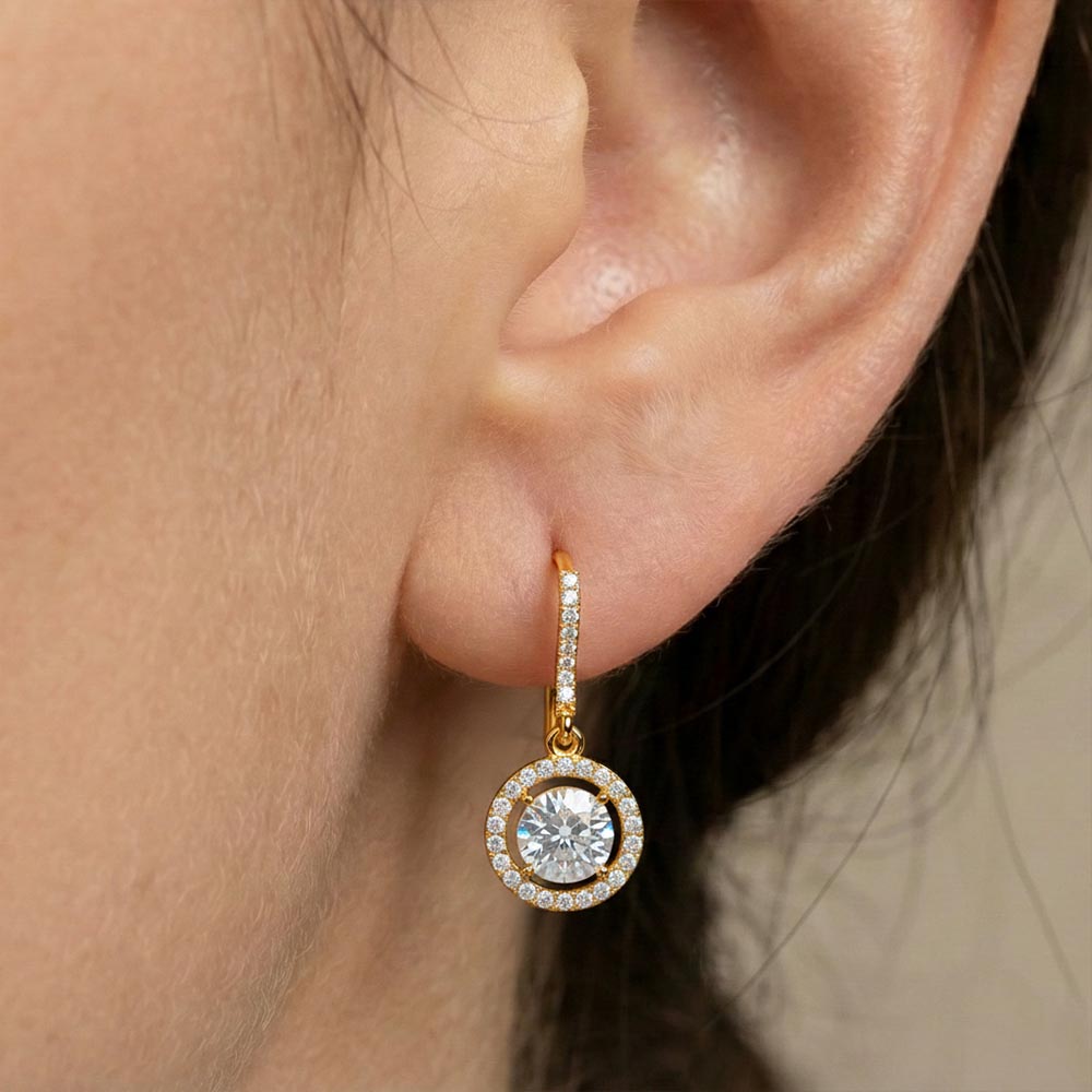 Gold hoop earring with a diamond on an ear