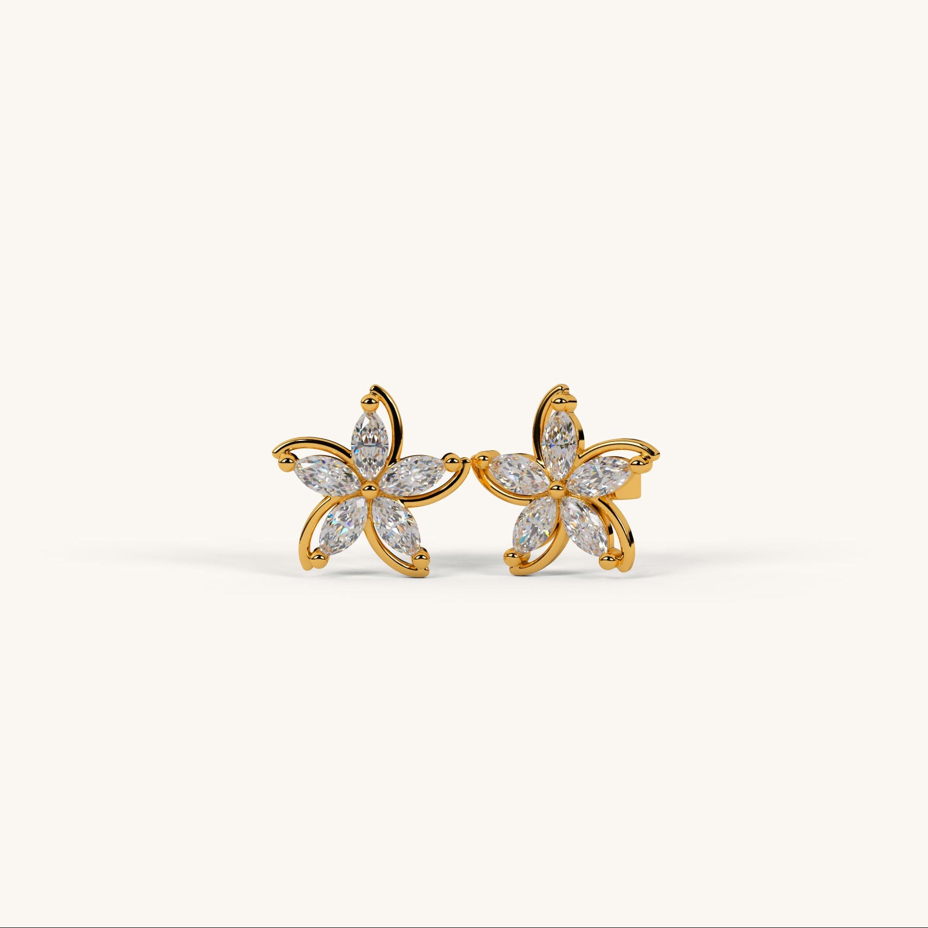 Gold flower-shaped earrings with clear gemstones on a white background