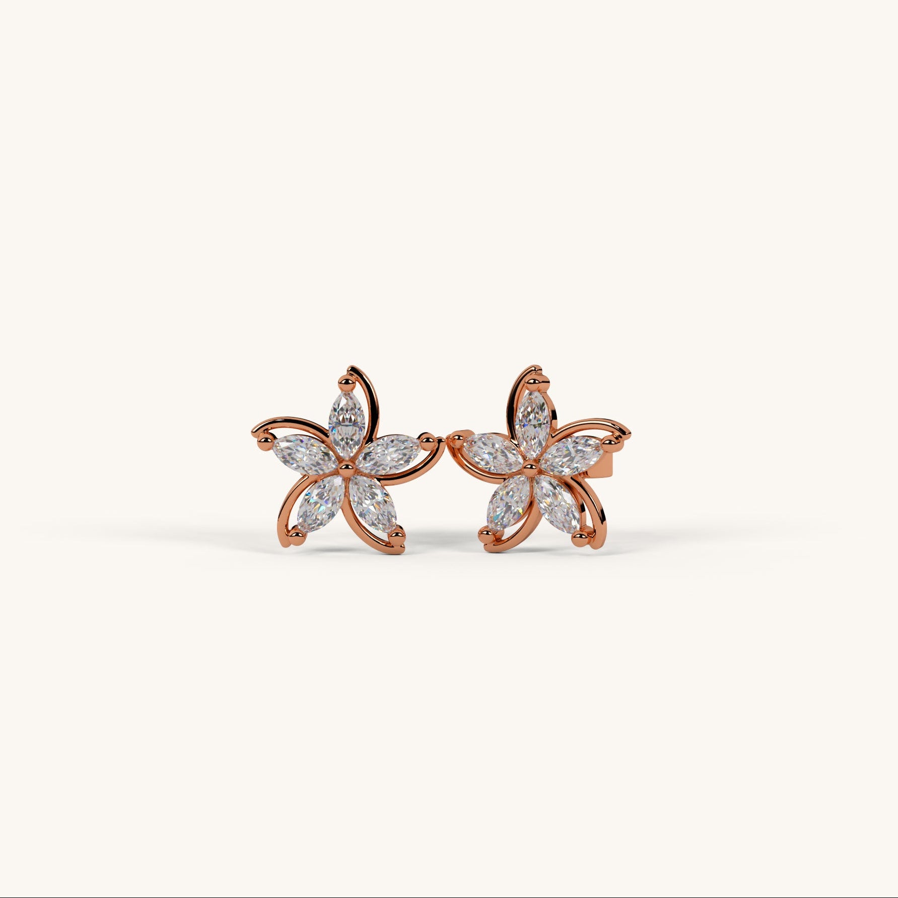 Pair of rose gold flower-shaped earrings with clear gemstones on a white background