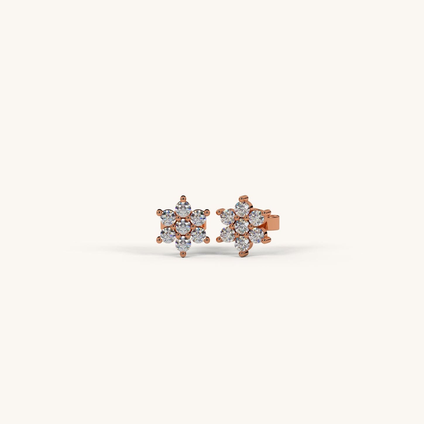 Pair of diamond stud earrings on a light beige background