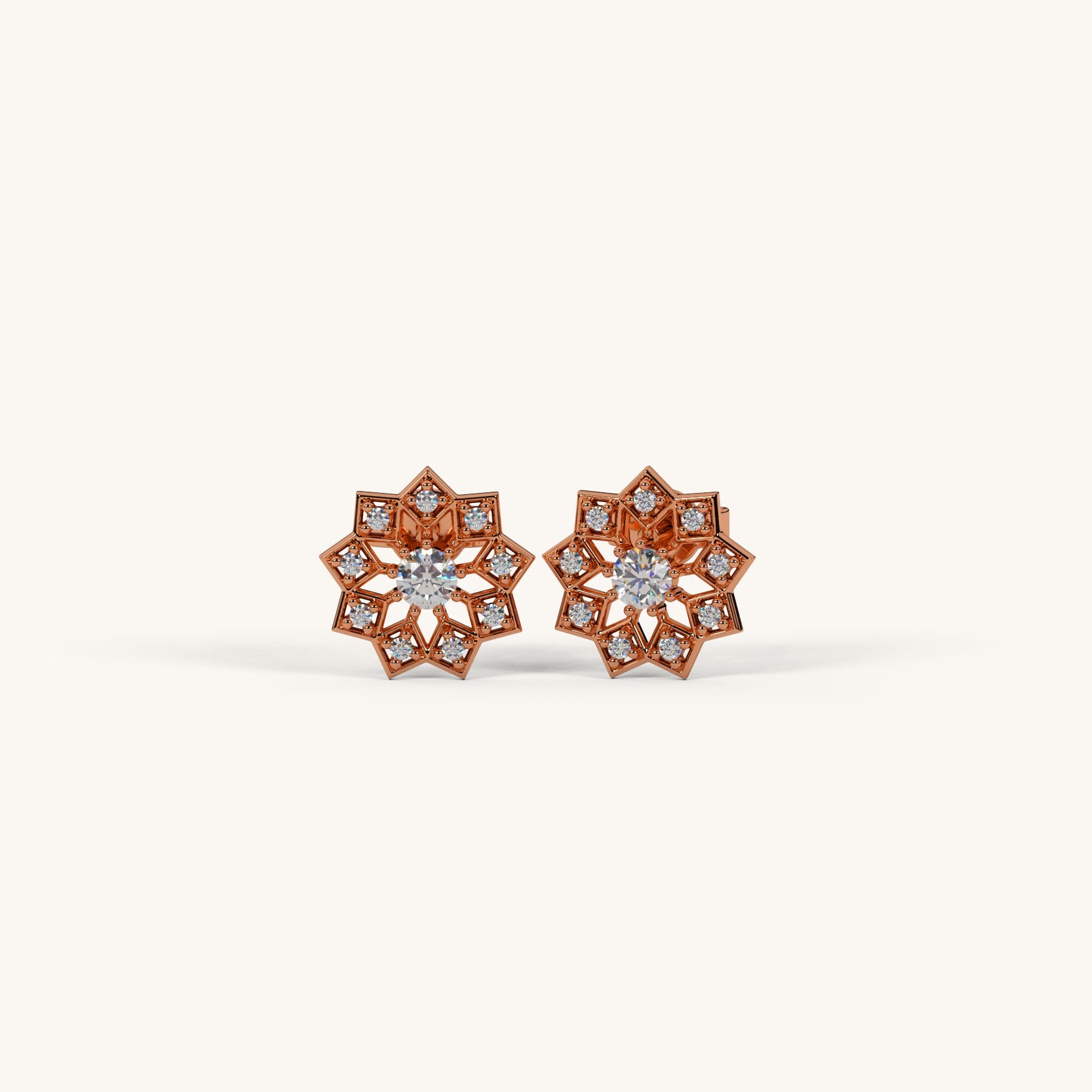 Pair of rose gold earrings with diamond accents on a white background