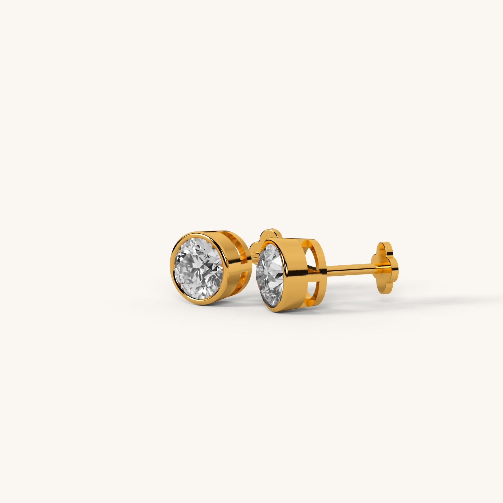 Gold stud earrings with clear gemstones on a white background