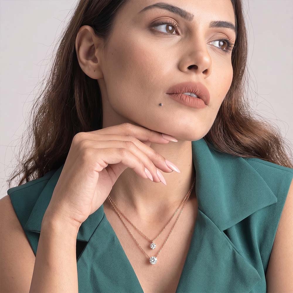Woman wearing a necklace with a diamond pendant against a neutral background